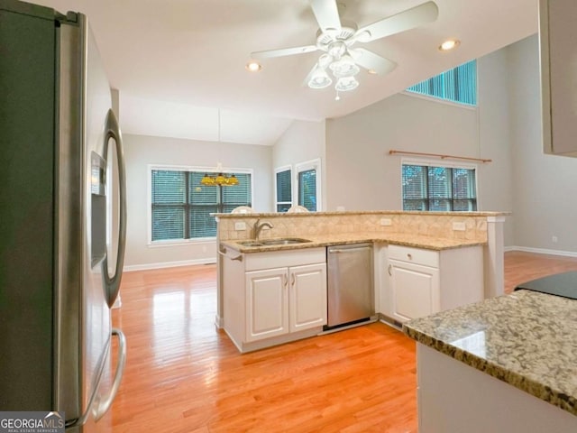 kitchen featuring white cabinets, a healthy amount of sunlight, light wood-type flooring, and stainless steel appliances