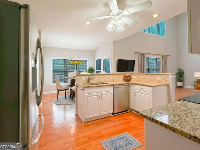 kitchen with white cabinets, appliances with stainless steel finishes, light wood-type flooring, and a healthy amount of sunlight