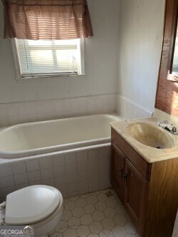 full bath featuring vanity and tiled tub