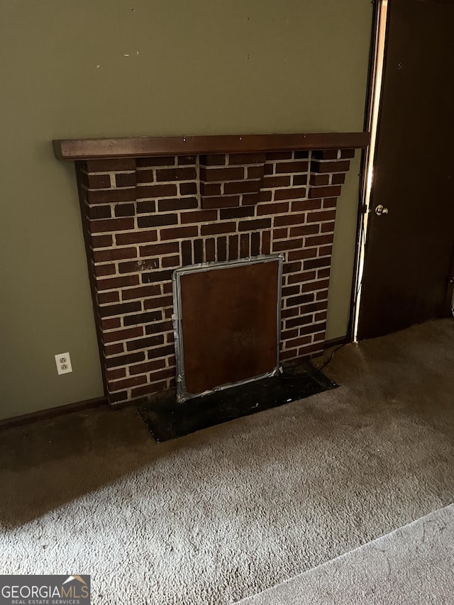 room details featuring a brick fireplace and carpet