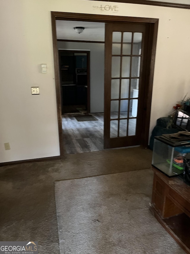 corridor with french doors and carpet flooring