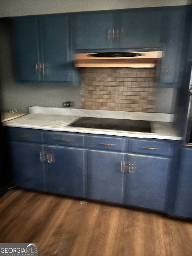 kitchen with light countertops, black electric stovetop, blue cabinets, and dark wood-style flooring