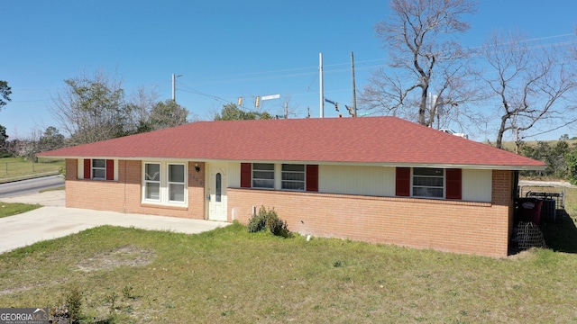 ranch-style house featuring brick siding and a front lawn