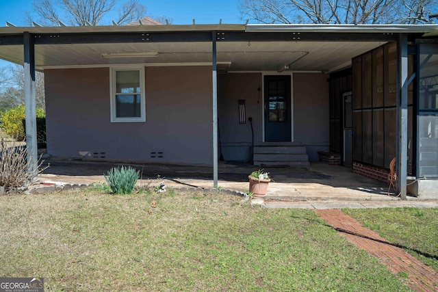 view of front of property with entry steps, a carport, and a front yard