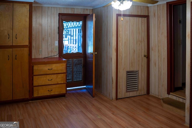 unfurnished bedroom featuring light wood-style floors, visible vents, and ornamental molding