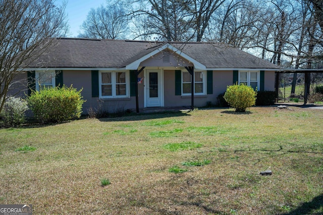 ranch-style home with stucco siding, a front yard, and a shingled roof