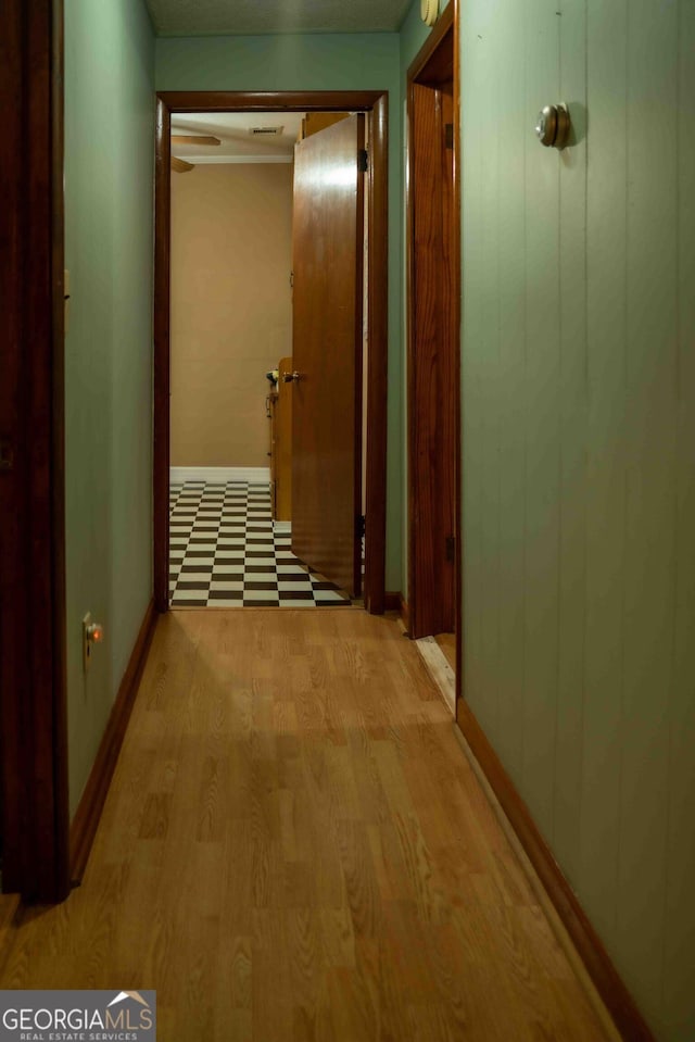 hall featuring light wood-style flooring and baseboards