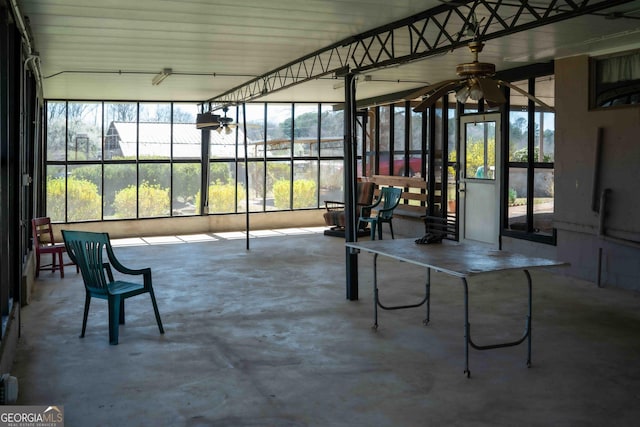 unfurnished sunroom with a ceiling fan and a wealth of natural light