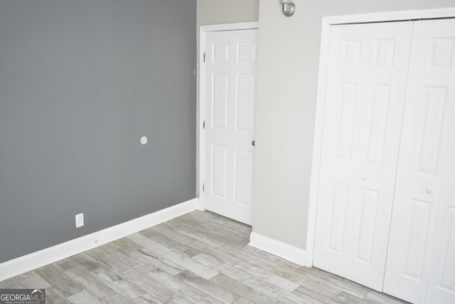 110 Wildwood Cir, Gainesville, GA 30501 - unfurnished bedroom featuring a closet, light wood finished floors, and baseboards