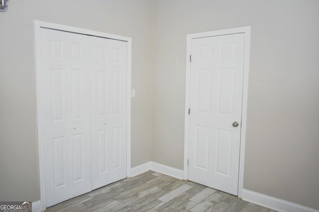 110 Wildwood Cir, Gainesville, GA 30501 - unfurnished bedroom featuring a closet, light wood-type flooring, and baseboards