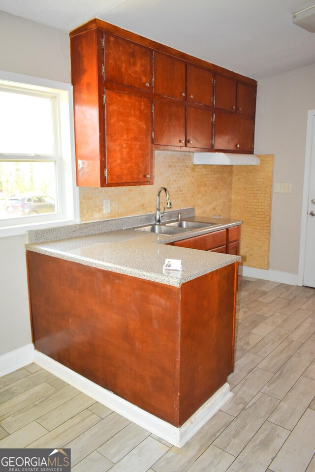 110 Wildwood Cir, Gainesville, GA 30501 - kitchen featuring baseboards, wood finish floors, a peninsula, a sink, and tasteful backsplash