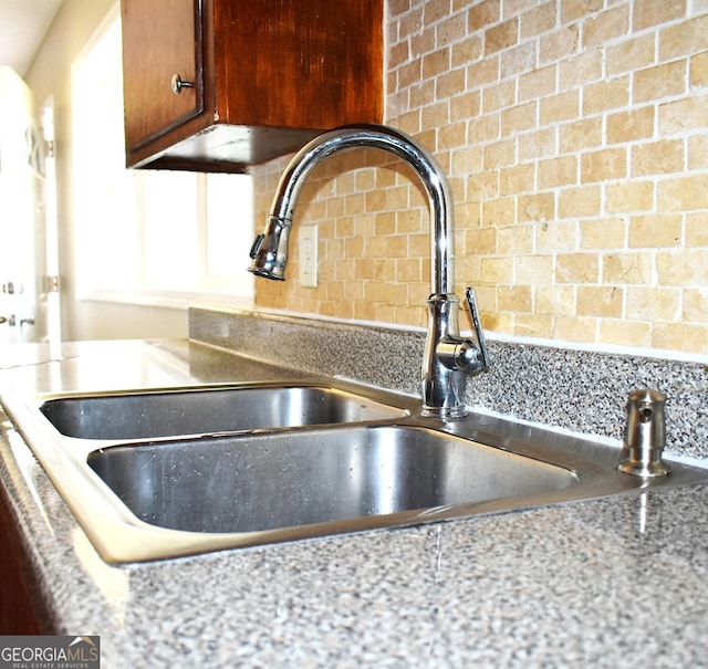 110 Wildwood Cir, Gainesville, GA 30501 - room details with backsplash, light stone countertops, brown cabinets, and a sink
