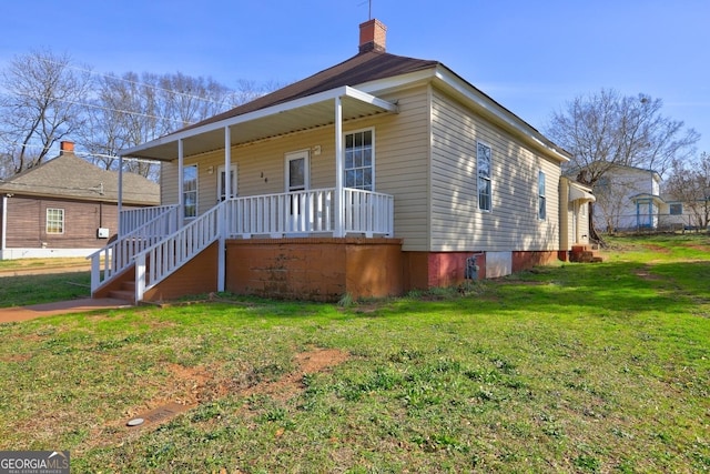 view of property exterior with a chimney, covered porch, and a lawn