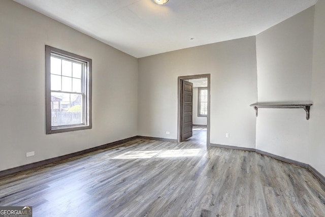 spare room featuring wood finished floors and baseboards