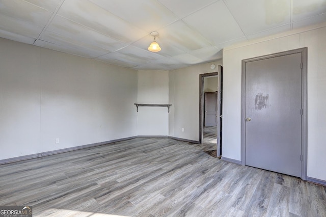 unfurnished room with wood finished floors and baseboards