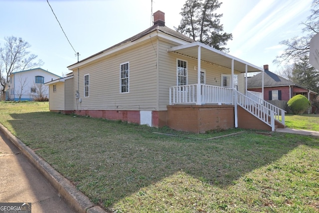 view of home's exterior with a yard, a porch, and a chimney