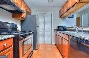 kitchen with under cabinet range hood, brown cabinets, dishwasher, and electric stove