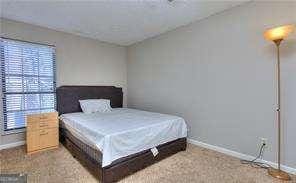 bedroom featuring multiple windows, baseboards, and carpet floors