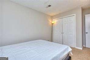 bedroom featuring a closet, carpet floors, and visible vents