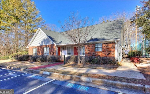 view of front of home featuring brick siding and uncovered parking