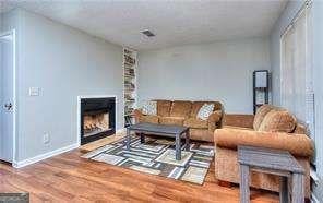 living room featuring baseboards, wood finished floors, and a fireplace