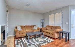 living room with baseboards, wood finished floors, and a fireplace