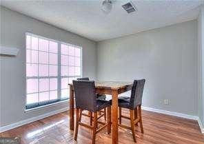 dining room featuring wood finished floors, visible vents, and baseboards