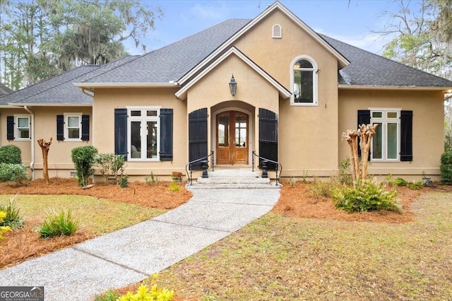 view of front facade with crawl space, french doors, a shingled roof, and stucco siding