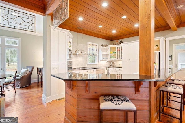 kitchen featuring backsplash, ornamental molding, wooden ceiling, white cabinets, and stainless steel appliances