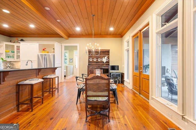 dining area featuring light wood finished floors, crown molding, wood ceiling, recessed lighting, and a notable chandelier