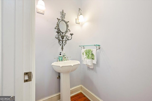 bathroom with wood finished floors and baseboards