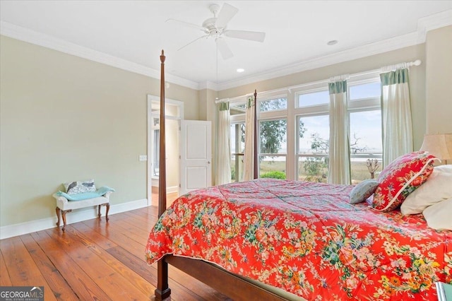 bedroom featuring baseboards, wood-type flooring, ornamental molding, and a ceiling fan
