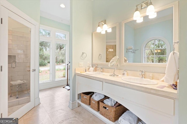 bathroom with double vanity, a shower stall, ornamental molding, and a sink