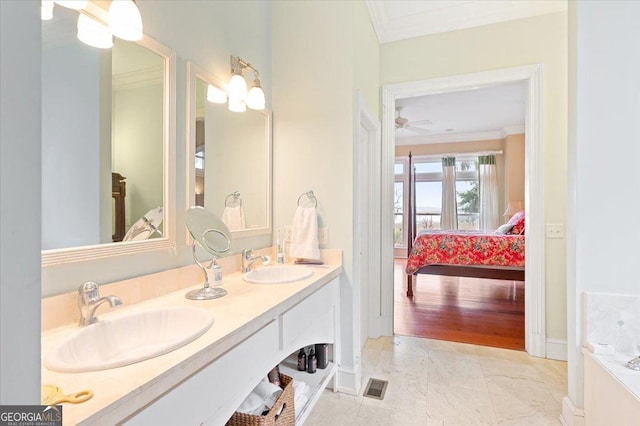 ensuite bathroom featuring a sink, connected bathroom, and ornamental molding