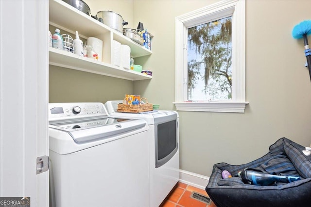 washroom with tile patterned flooring, visible vents, baseboards, laundry area, and independent washer and dryer
