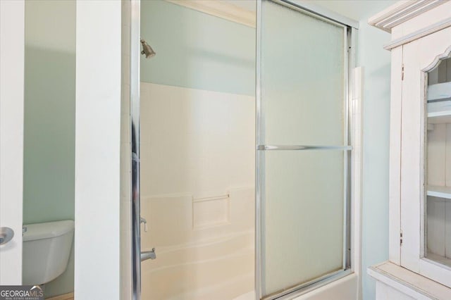 full bath featuring toilet and bath / shower combo with glass door