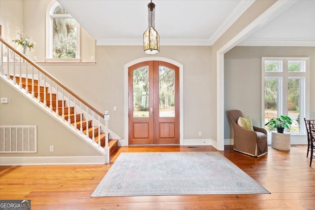 entryway featuring visible vents, arched walkways, stairs, french doors, and wood-type flooring