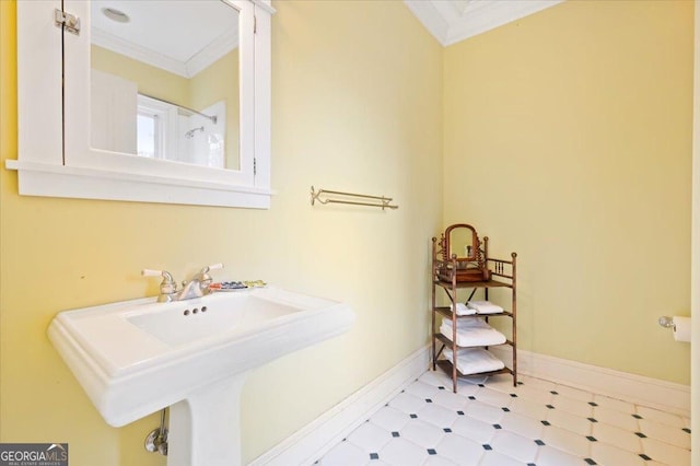 bathroom with a sink, baseboards, crown molding, and tile patterned floors
