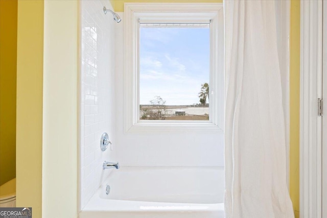 full bath featuring toilet and shower / tub combo with curtain