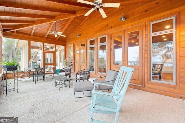 sunroom with lofted ceiling with beams, a ceiling fan, and wooden ceiling