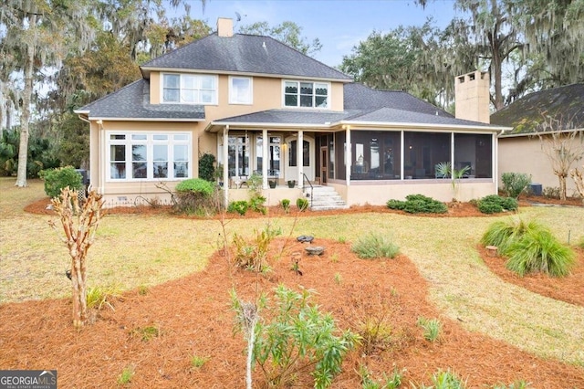 back of house with a patio, a yard, a sunroom, and a chimney