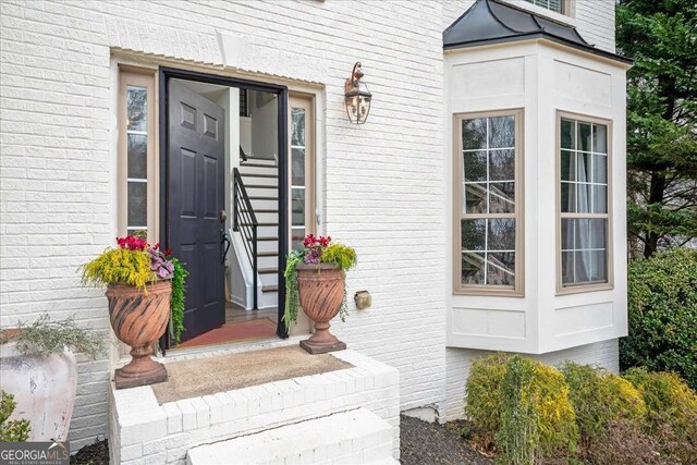 view of exterior entry with brick siding