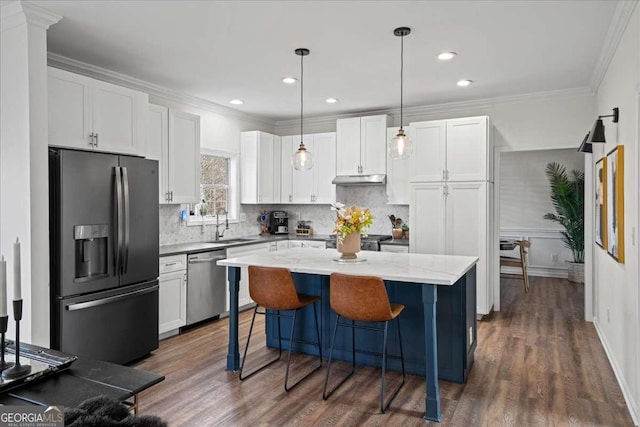 kitchen with white cabinets, ornamental molding, under cabinet range hood, and stainless steel appliances