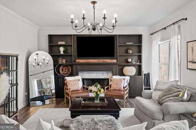 living area featuring wood finished floors, a fireplace, a chandelier, and ornamental molding