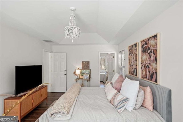 bedroom with visible vents, a notable chandelier, a tray ceiling, dark wood-style floors, and lofted ceiling