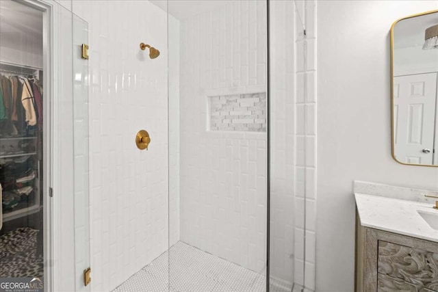 bathroom featuring vanity, a stall shower, and a spacious closet