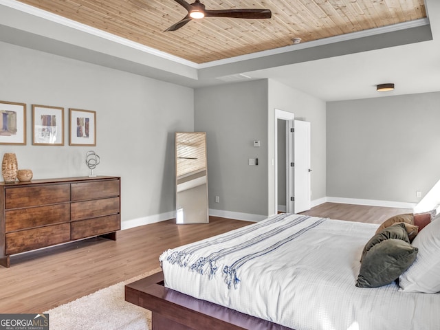 bedroom with a ceiling fan, wood finished floors, baseboards, wood ceiling, and a raised ceiling