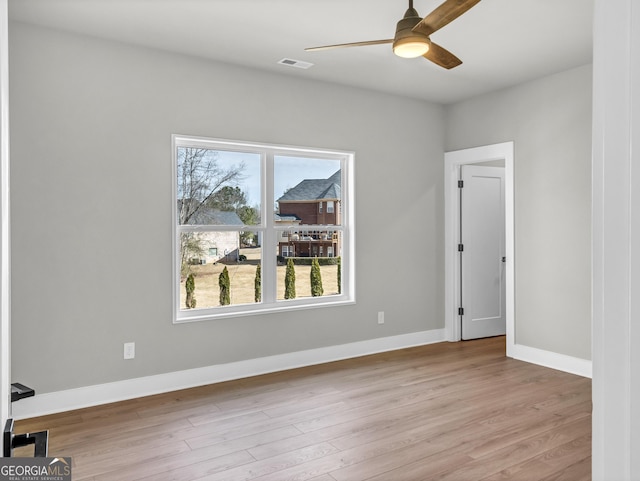 unfurnished room featuring visible vents, baseboards, wood finished floors, and a ceiling fan