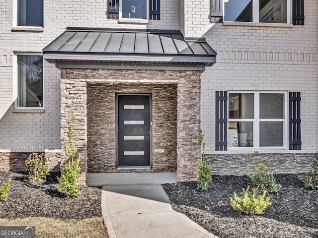 view of exterior entry with a standing seam roof and metal roof