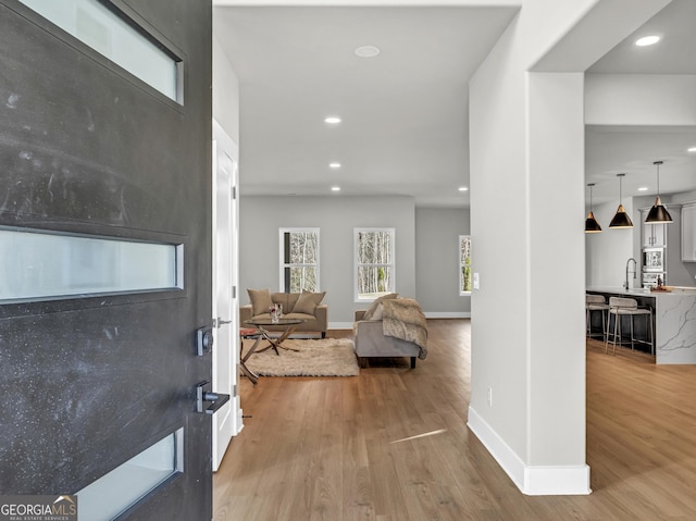 entryway with recessed lighting, baseboards, and light wood-style floors